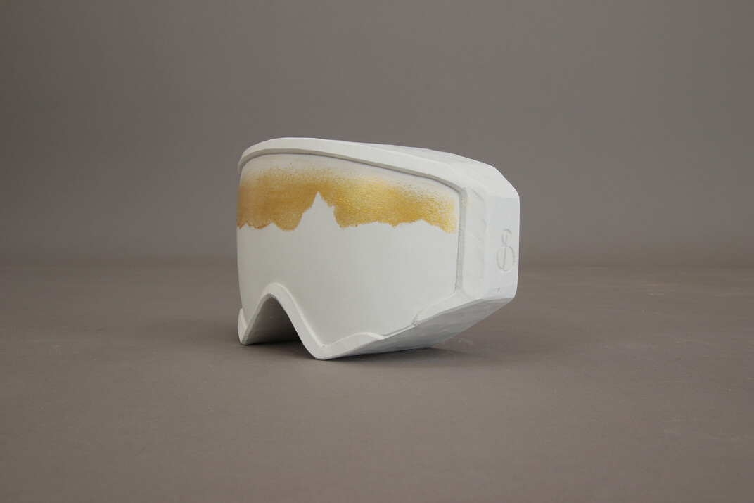 Skibrillen-förmiger Pokal aus Gips gegossen in einem unreinen Weiß mit goldenen Akzenten und der Bergskyline