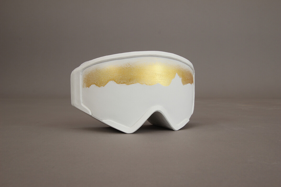 Skibrillen-förmiger Pokal aus Gips gegossen in einem unreinen Weiß mit goldenen Akzenten und der Bergskyline