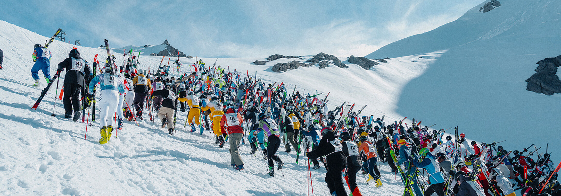 Aufstieg auf den Schmerzensberg beim Weissen Rausch, die Teilnehemr tragen ihre Ski und laufen die steil Piste hinauf.