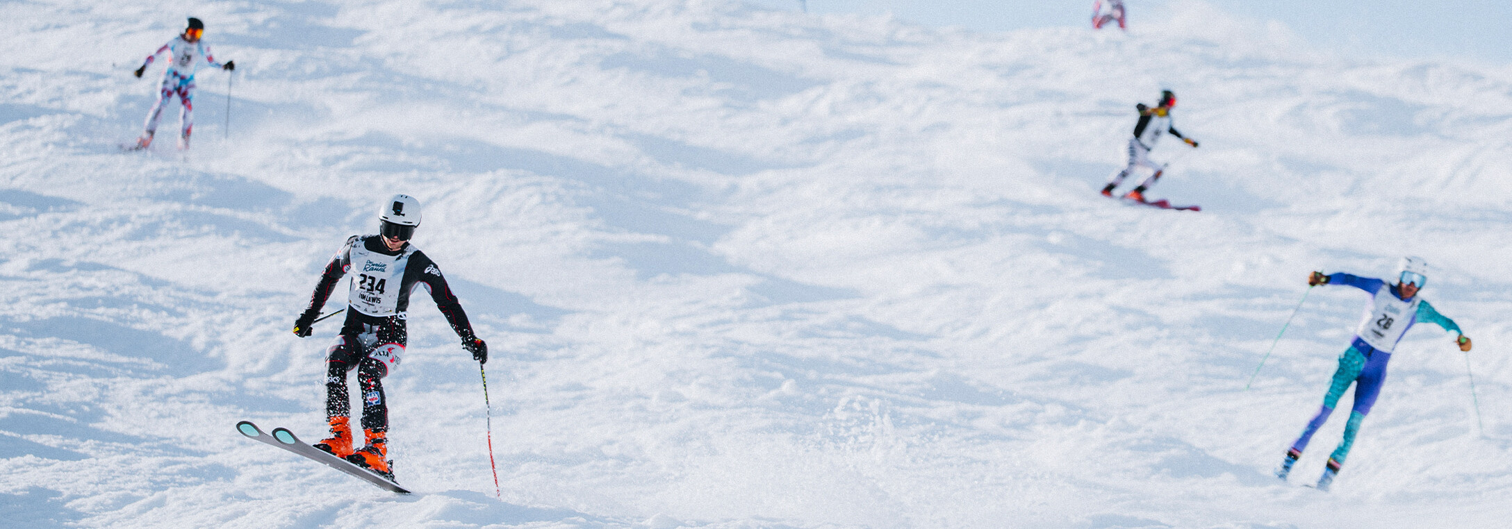 Skifahrer kämpfen sich die steile buckelige Kandahar Piste runter